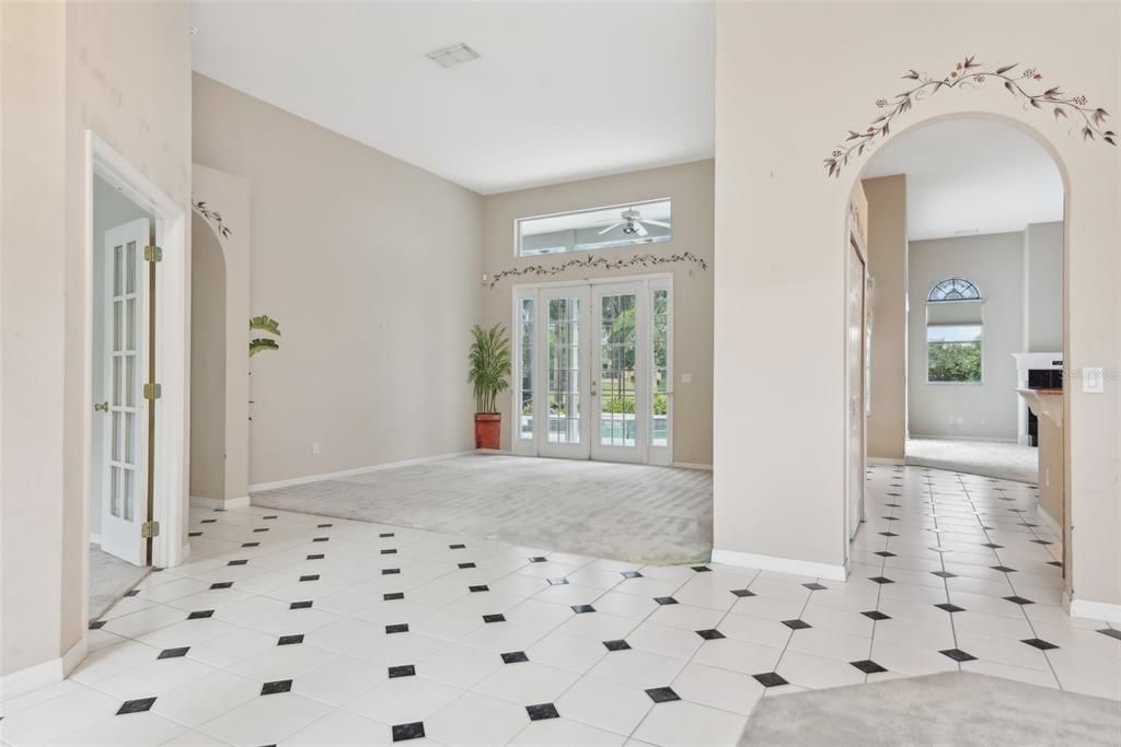 View from Front Door! Office and Primary Suite off to the left, Formal Living straight ahead, formal dining off to the right and Main Living area and Kitchen through the archway. 13 FT CEILINGS!