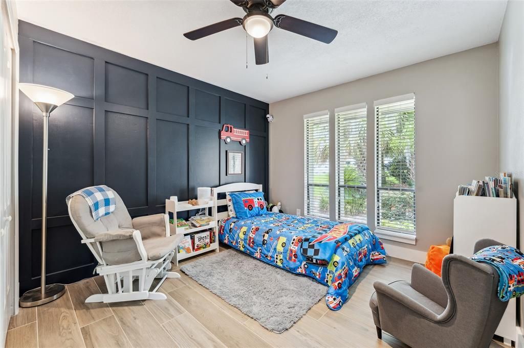 bedroom with beautiful decorative wood accent wall, ceiling fan