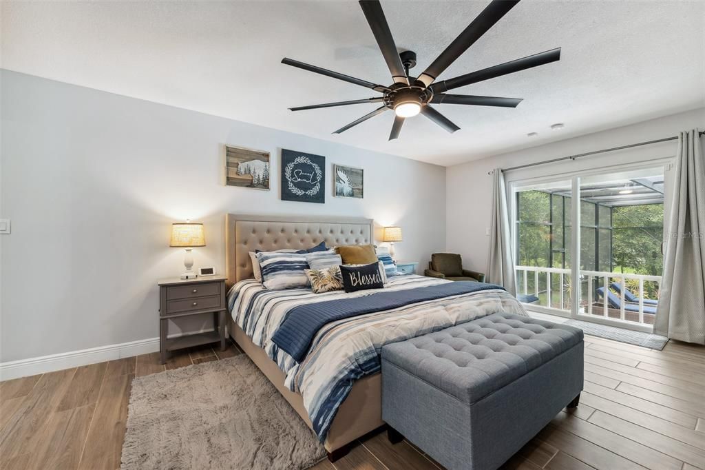 This Primary suite is perfect to enjoy sipping coffee or breakfast in bed . Featuring large ceiling fan, wood grain ceramic flooring and views of the pool