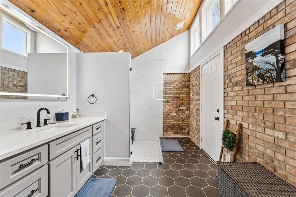 OMG!!!!! You wont want to leave this spa like primary ensuite bath with walk in shower, double vanities that have LED mirrors, and this gorgeous brick wall, wood ceilings, and natural light