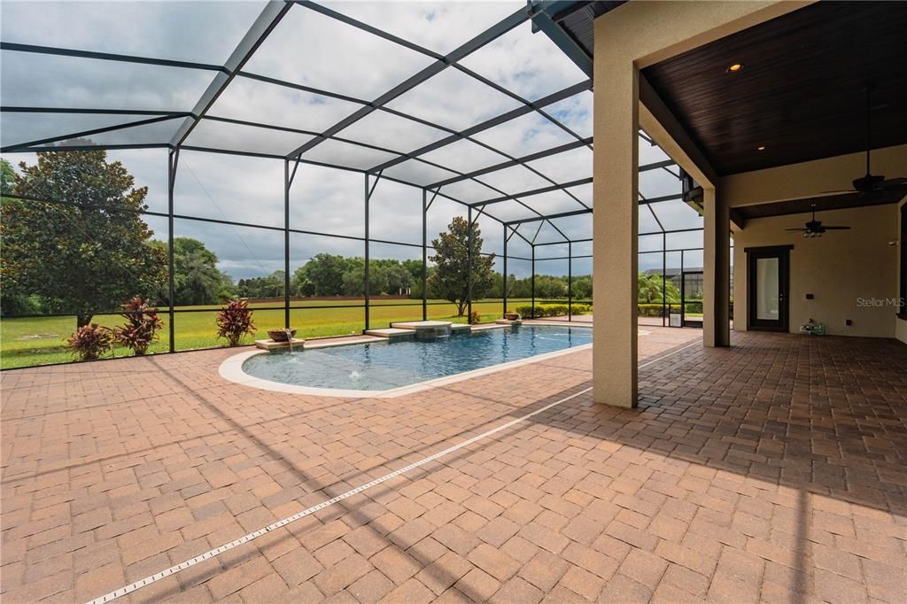 Walking out to your pool with green space behind it.