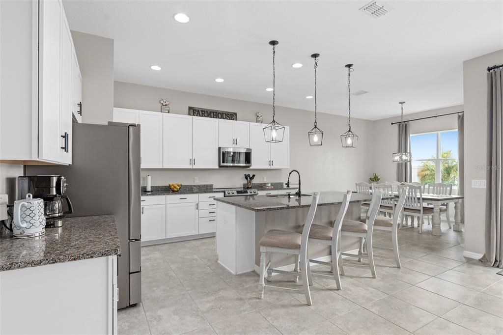 Gorgeous chef inspired kitchen with a large island, stainless steel appliances and granite countertops.