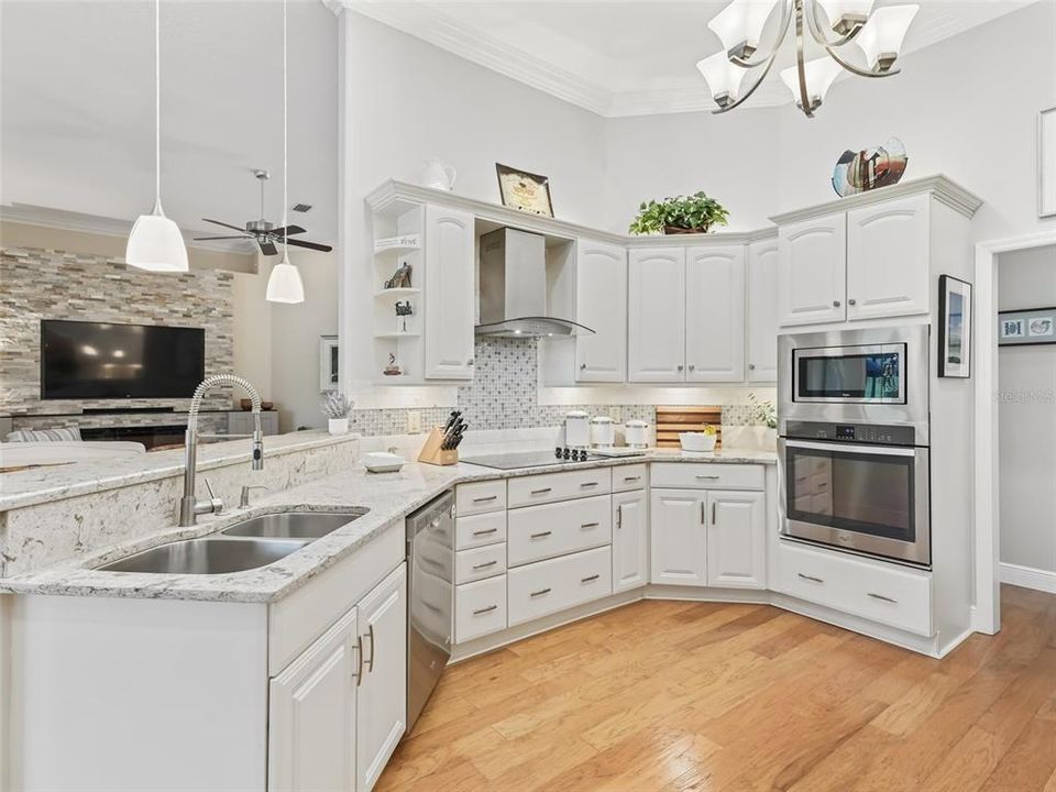 The double sink, dishwasher, cooktop with modern vent, microwave and oven create a great workflow.