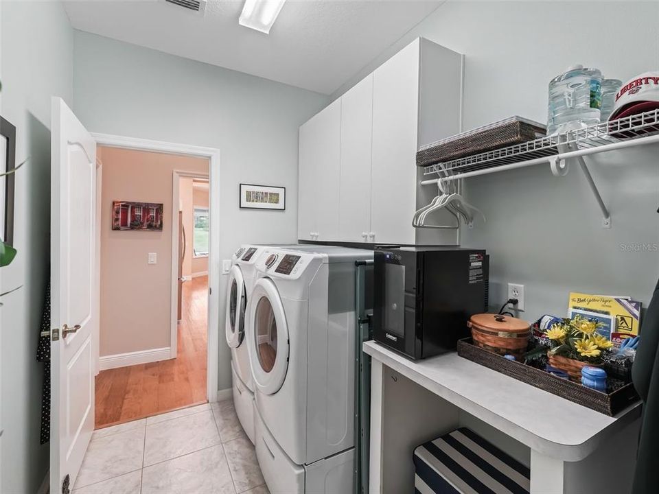 Laundry room has room to sort and fold, store extra supplies in the overhead cabinets and the washer and dryer is included in the sale.