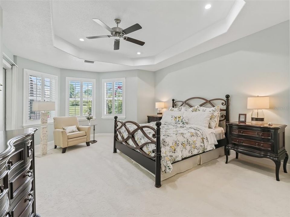 This is the luxury you have wanted in a Primary bedroom.  A tray ceiling, windows with plantation shutters, soft carpet to tickle your feet, and a sliding door into the Florida room, where you can start your day.