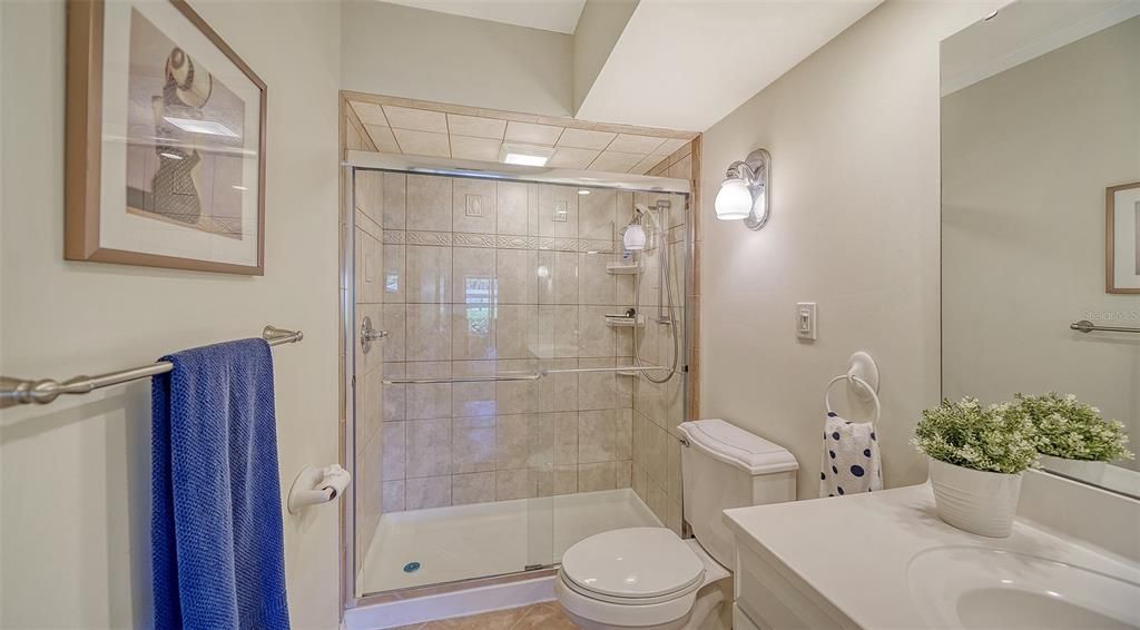 Guest bathroom with glassed walk-in shower.