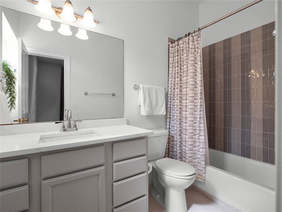 5th Bedroom Ensuite Bathroom with elevated fixtures, designer tile and quartz countertops.