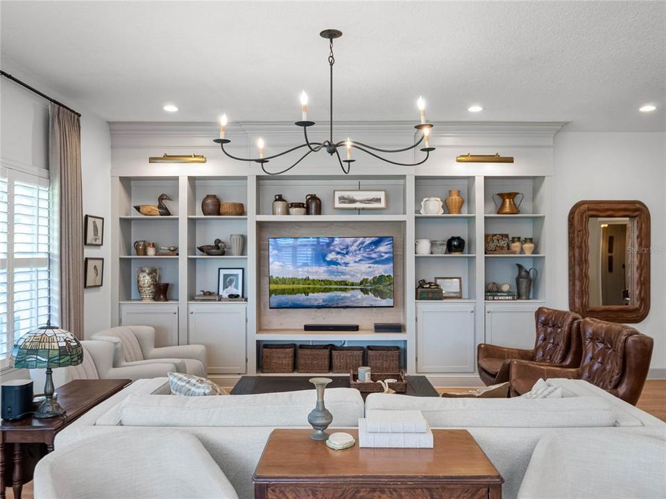 Living Room/Family Room 1st Level with custom cased shelving and elevated lighting.