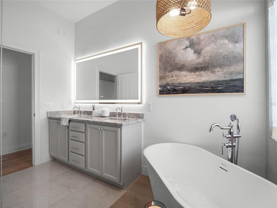 Primary Spa Bathroom with garden tub, double sink vanity, lighted mirror, and dual fixture walk-in shower.