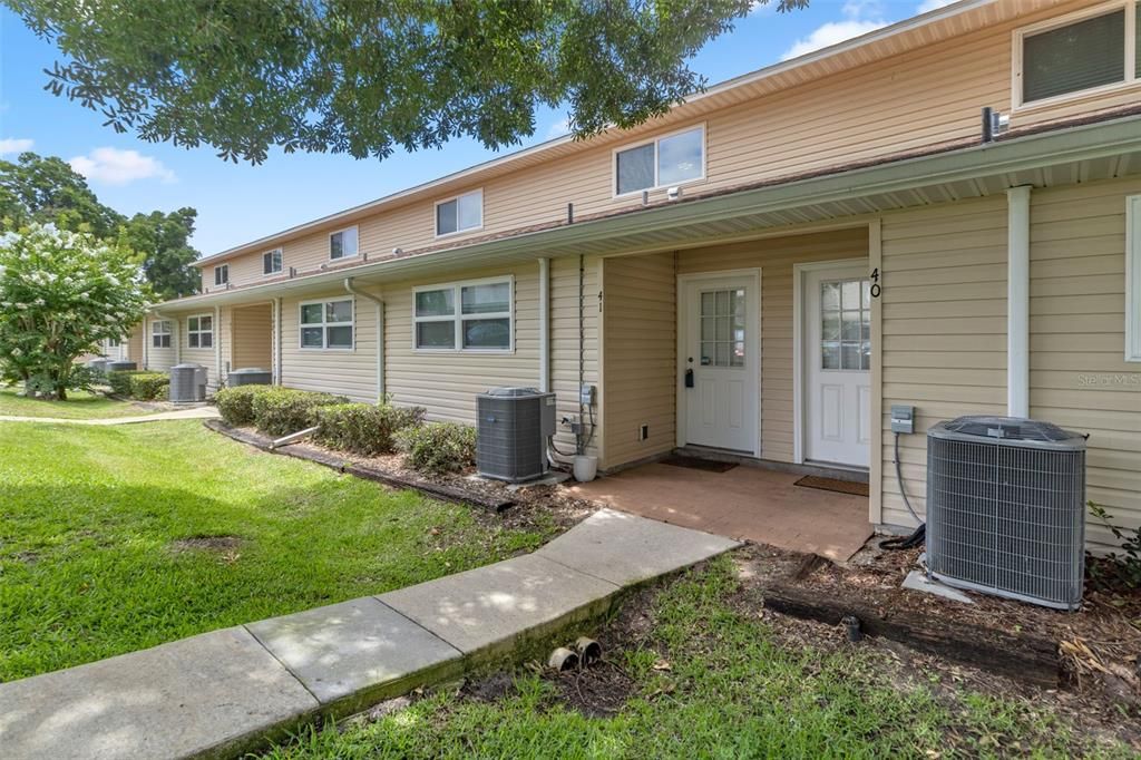 Front entrance of condo with maintained A/C