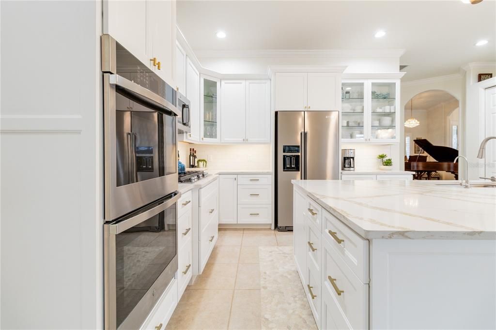 Gourmet kitchen with top of line stainless steel appliances, gas stove top, designer stone pebble flooring and a walk in pantry.