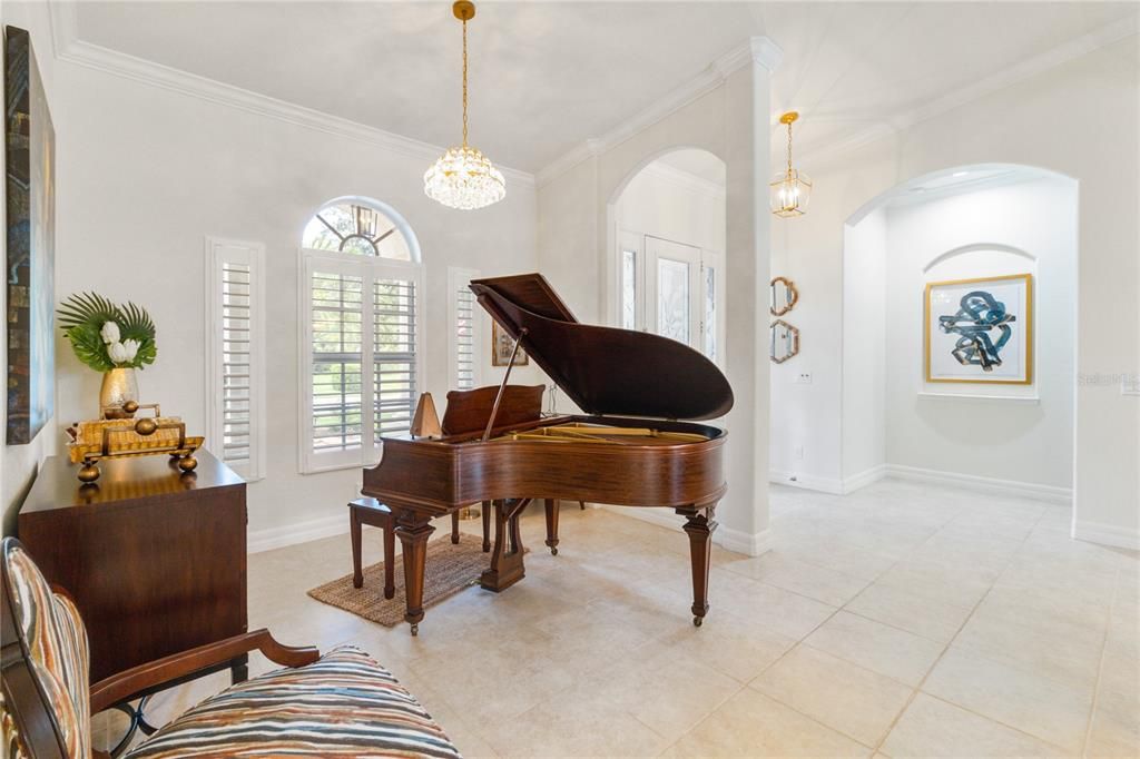 Semi formal space in front of the home with a gorgeous chandelier and large window looking out in front porch. This area is large enough to fit in a grand piano but can also be used for seating or even  table and chairs