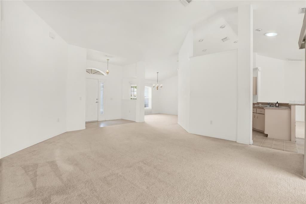 Living Room view to front door and formal dining to kitchen