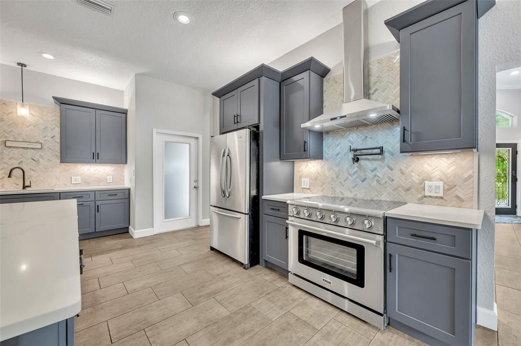 Newly remodeled kitchen with view of 6-burner THOR range and stylish backsplash