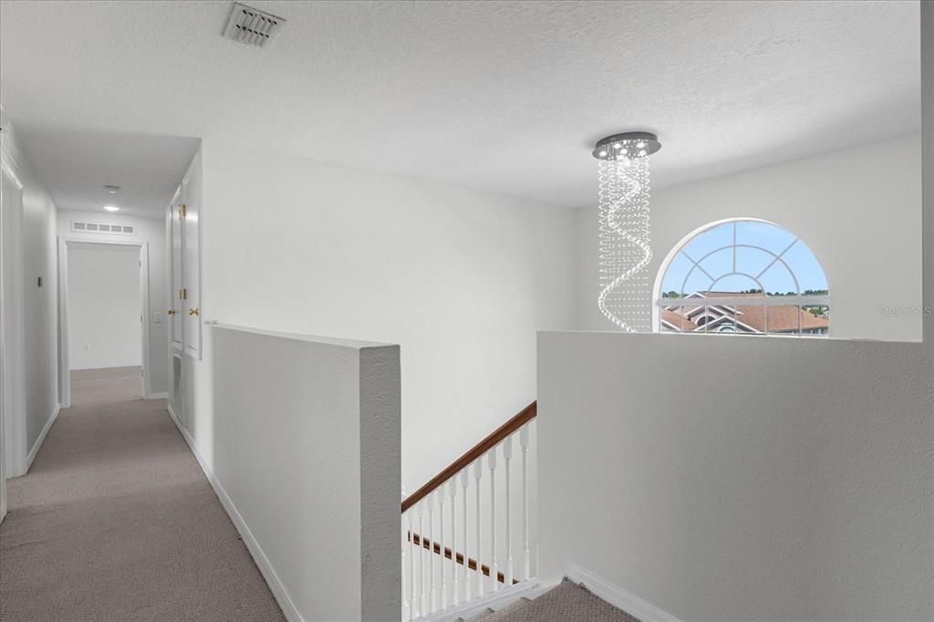 SECOND FLOOR VIEW OF HALL WAY AND CHANDELIER