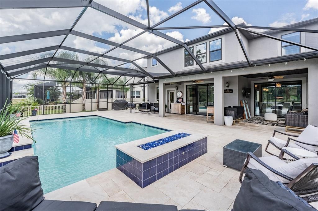 pool with propane fire pit and travertine pavers