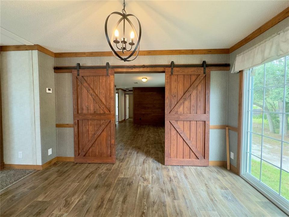 dining room, sliders to right, family room through barn doors