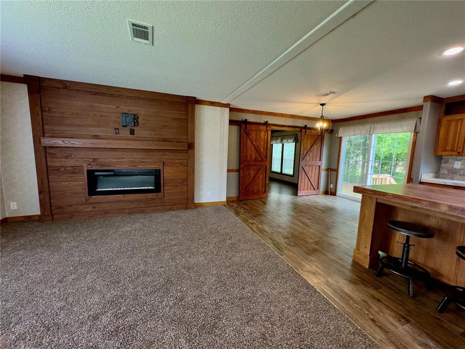 living room fireplace, sliding doors from dining room, barn doors to family room