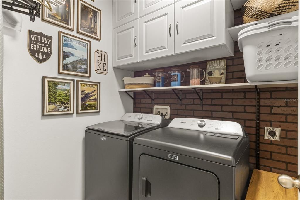 Full laundry room with storage cabinets, washer and dryer hook ups.