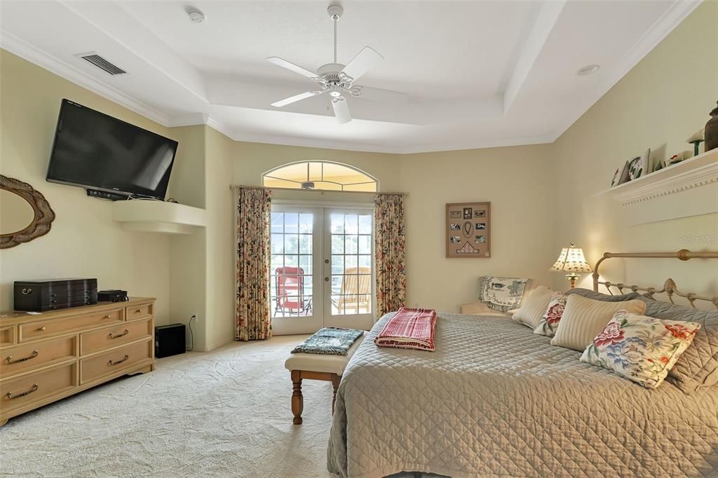 Primary bedroom with view of pool and lake