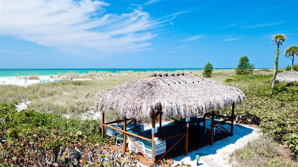 TIKI HUTS WITH BEACH CHAIRS AT ENTRANCE OF BEACH