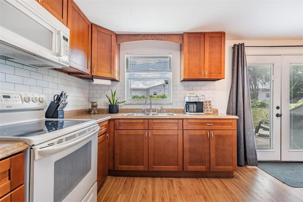 kitchen features stylish wood shaker-style cabinets, subway tile backsplash, Formica countertops and built-in storage shelves.