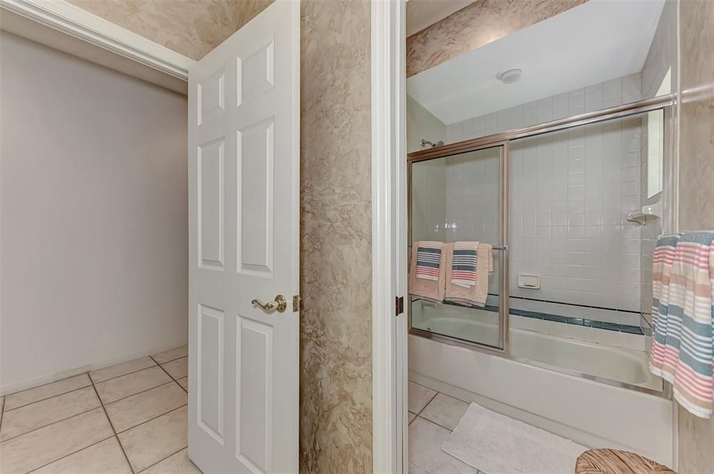 guest bath with pocket door to water closet and tub/shower combo