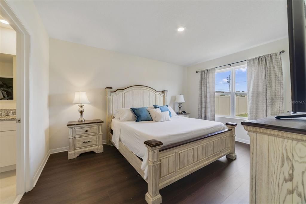 The flooring transitions from tile to wood laminate in the bedrooms, including the generous PRIMARY SUITE with a large window for great natural light that overlooks the backyard, private en-suite bath and WALK-IN CLOSET.