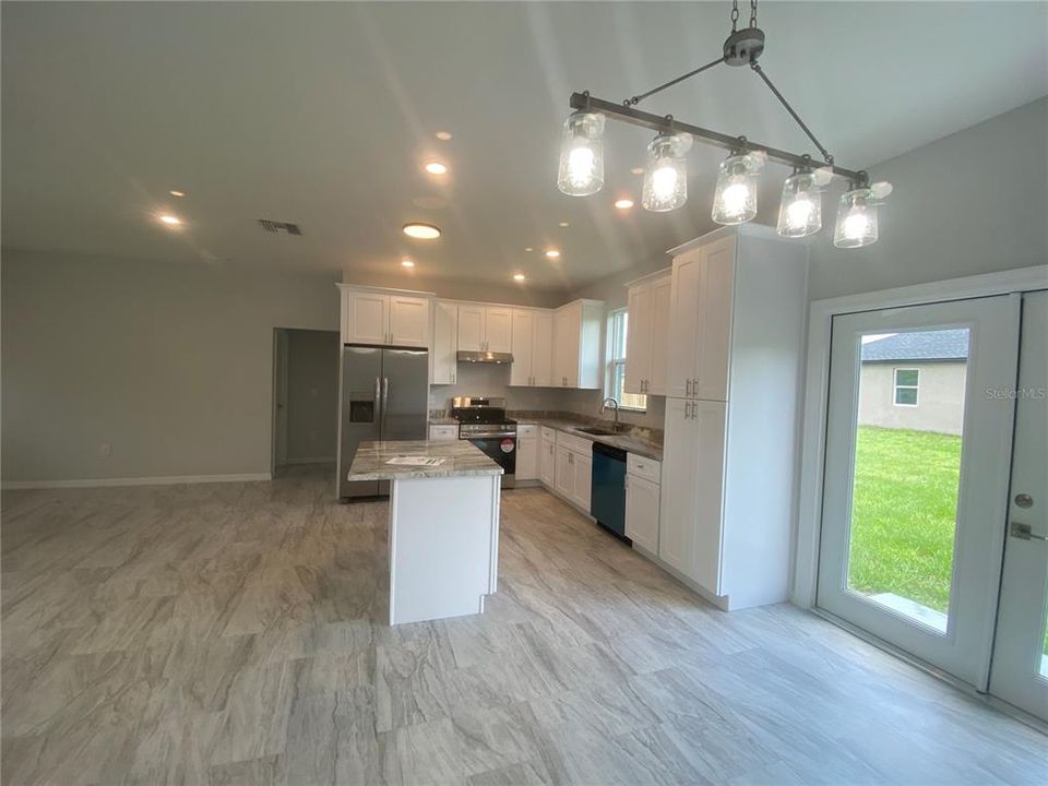 dining area to open kitchen with island, recessed lights, crown molding on cabinet tops