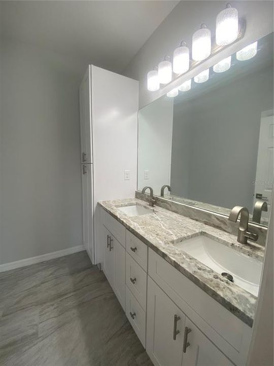 Primary bath with double vanity, granite counters, lien closet