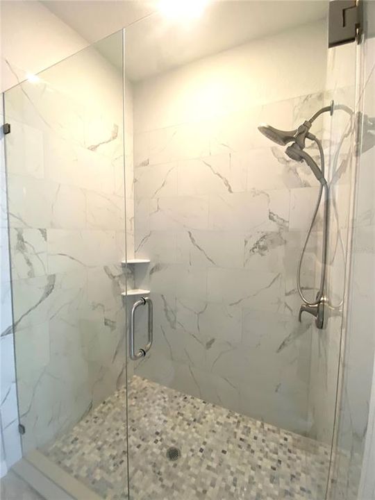 primary bath walk in tiled shower with glass shower door