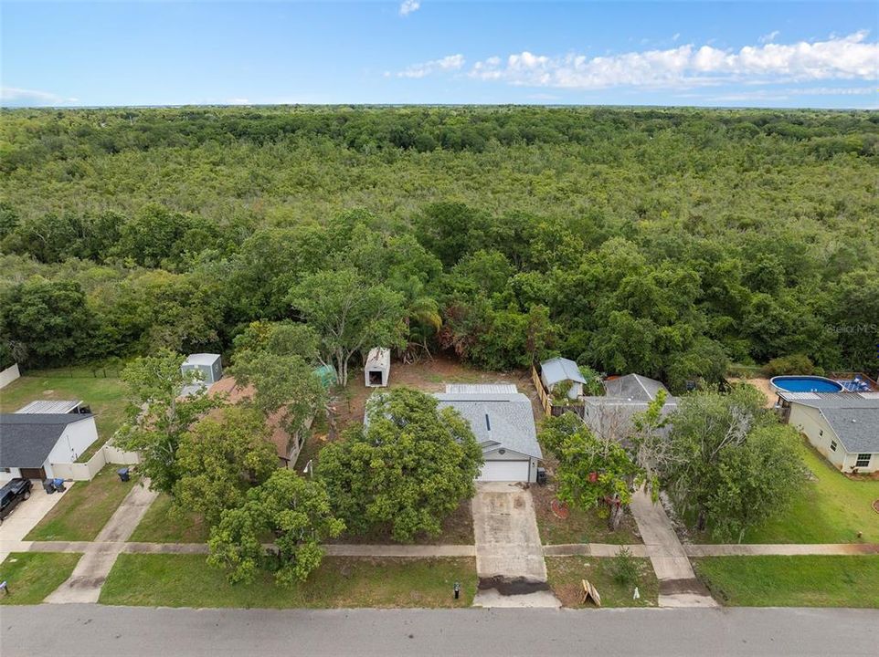 Here is the aerial view of the property located at 1669 Saratoga Dr, Titusville, FL 32796. The image shows the well-maintained home with its landscaped front yard, paved driveway, and surrounding greenery, providing a clear perspective of the property and its neighborhood.