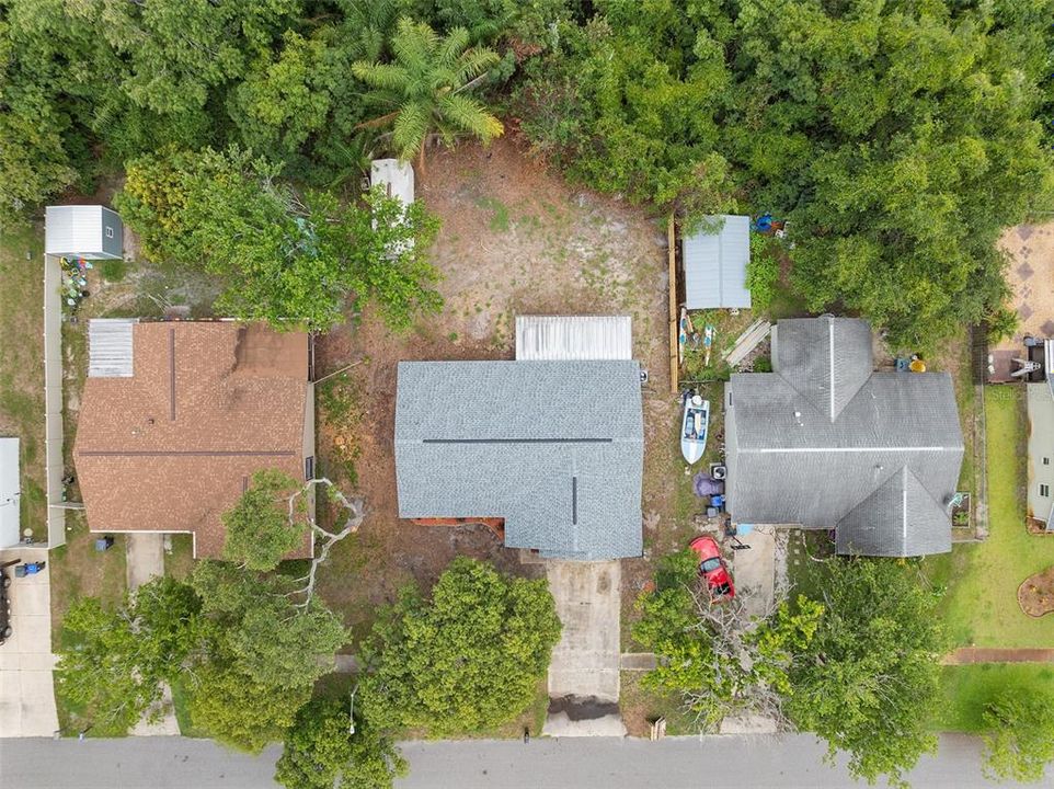 Here is the aerial view of the property located at 1669 Saratoga Dr, Titusville, FL 32796. The image shows the well-maintained home with its landscaped front yard, paved driveway, and surrounding greenery, providing a clear perspective of the property and its neighborhood.