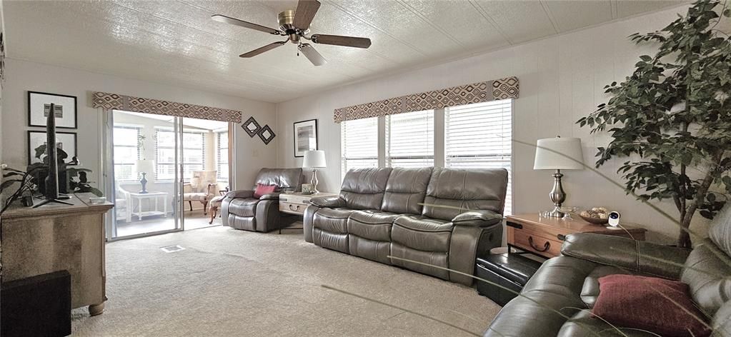 Living room includes carpet & ceiling fan