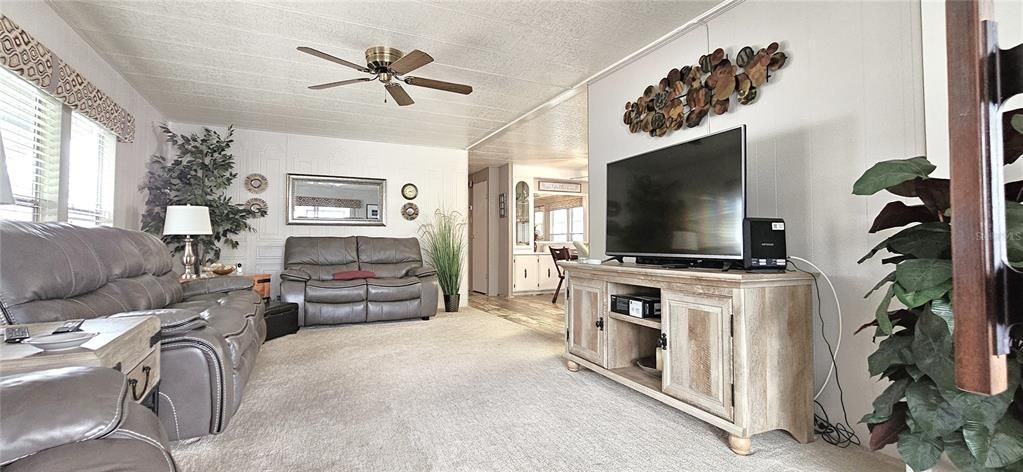 Living room includes carpet & ceiling fan