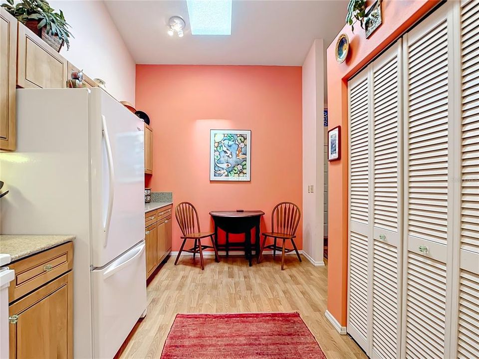 Kitchen showing skylight and eat in area, large double pantry closet on right