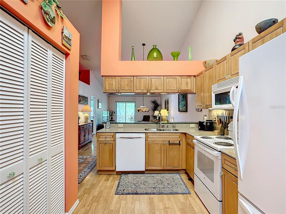 Kitchen view toward dining and living area. Note high vault ceilings