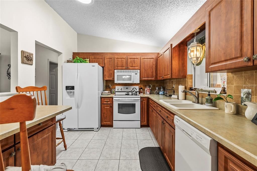 Kitchen with updated cabinets, tile floors and high ceilings.