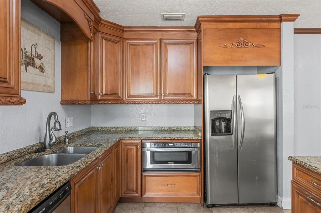 Kitchen Refrigerator & Stove with granite counter tops and breakfast bar