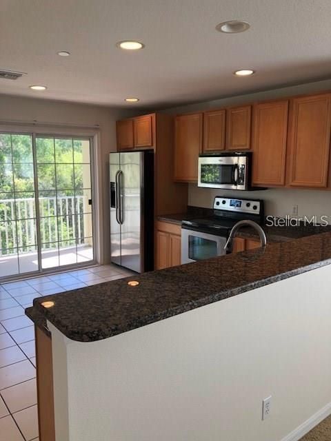 Very large eat-in kitchen with granite countertops and stainless steel appliances.