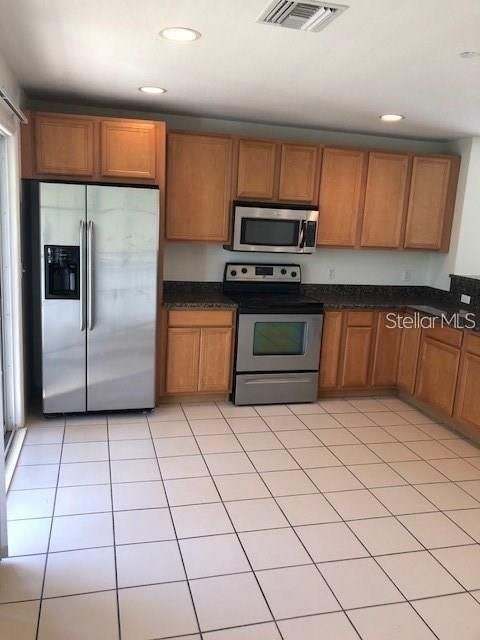 Very large eat-in kitchen with granite countertops and stainless steel appliances.
