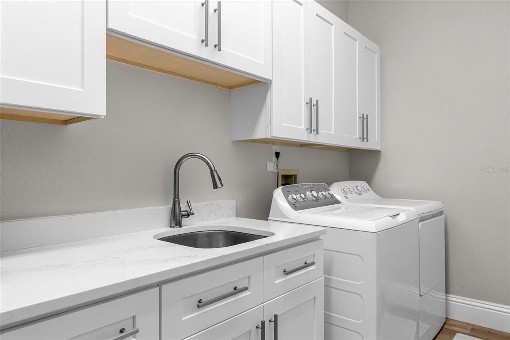 Laundry Room with full size fridge, custom cabinetry and quartz countertops