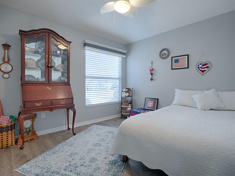 FRONT GUEST BEDROOM WITH CEILING FAN AND THE SAME LOVELY LVP FLOORING.