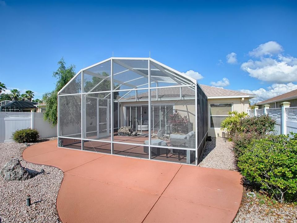 REAR OF THE HOME SHOWING THE SIZE OF THE BIRDCAGE AND AN OUTDOOR PATIO.