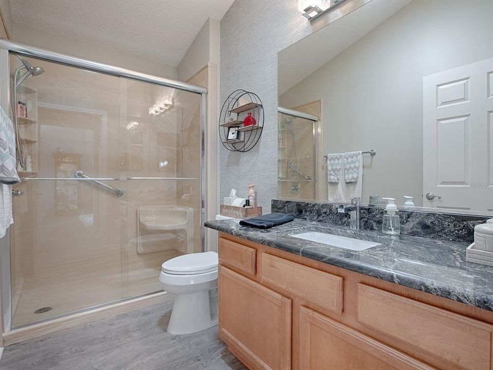 GUEST BATH WITH GRANITE COUNTER TOPS, NEWER FAUCET AND LIGHT FIXTURE, SOLAR TUBE, AND RENOVATED SHOWER WITH GASS ENCLOSURE. THERE IS A LINEN CLOSET IN THE HALLWAY.