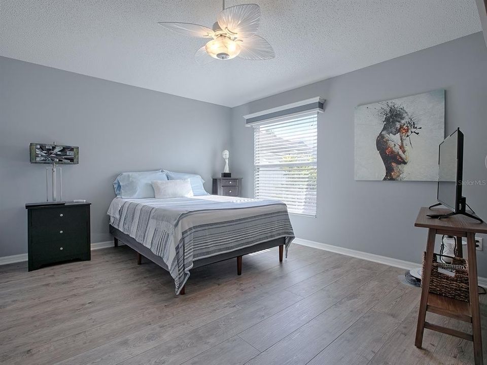 PRIMARY BEDROOM WITH VAULTED CEILING AND CEILING FAN.