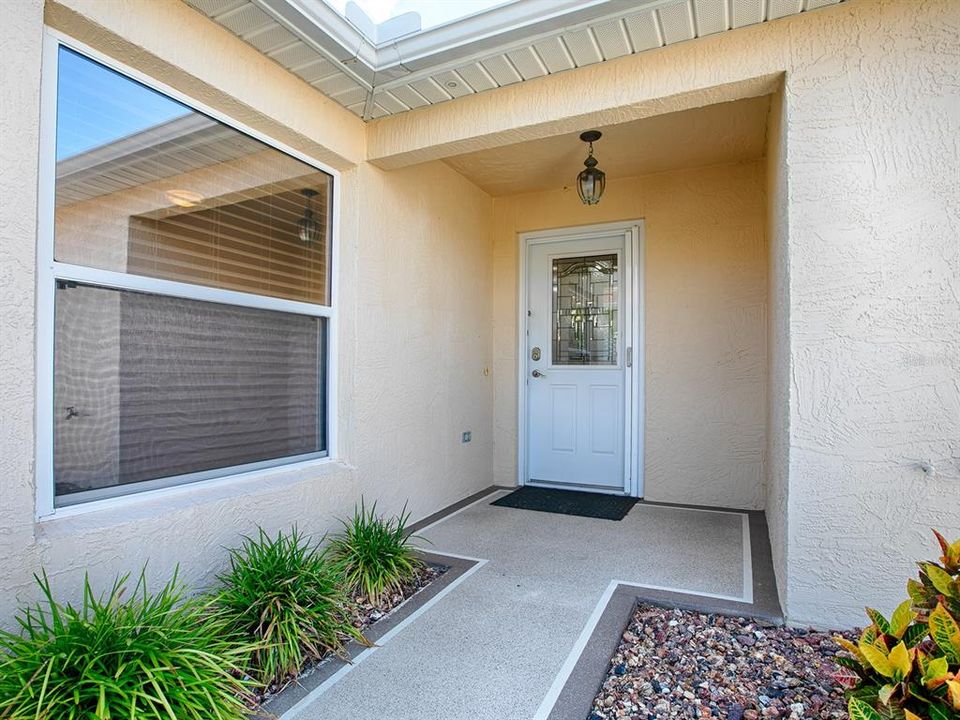 PAINTED WALKWAY WITH LEADED GLASS FRONT DOOR MAKES FOR NICE UPGRADED ENTRANCE.