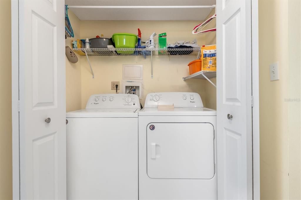 Laundry closet with storage shelf.