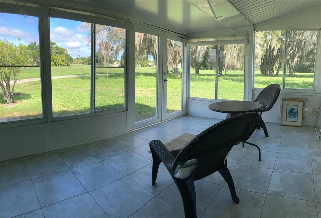 Enclosed lanai surface is tiled, ceiling fan offers a breeze.