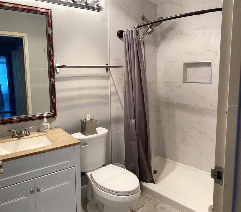 Primary bath, lovely mirror frame and shelving.